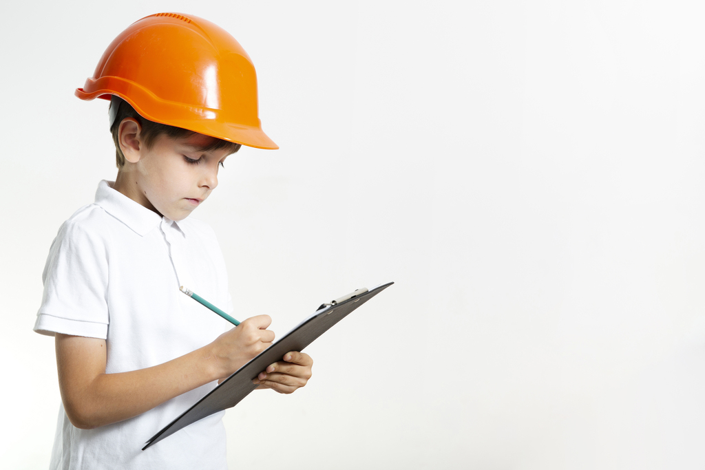 Kind mit Schutzhelm prüft eine Checkliste